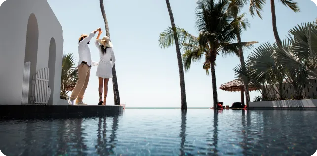 Couple heureux au bord d'une piscine luxueuse
